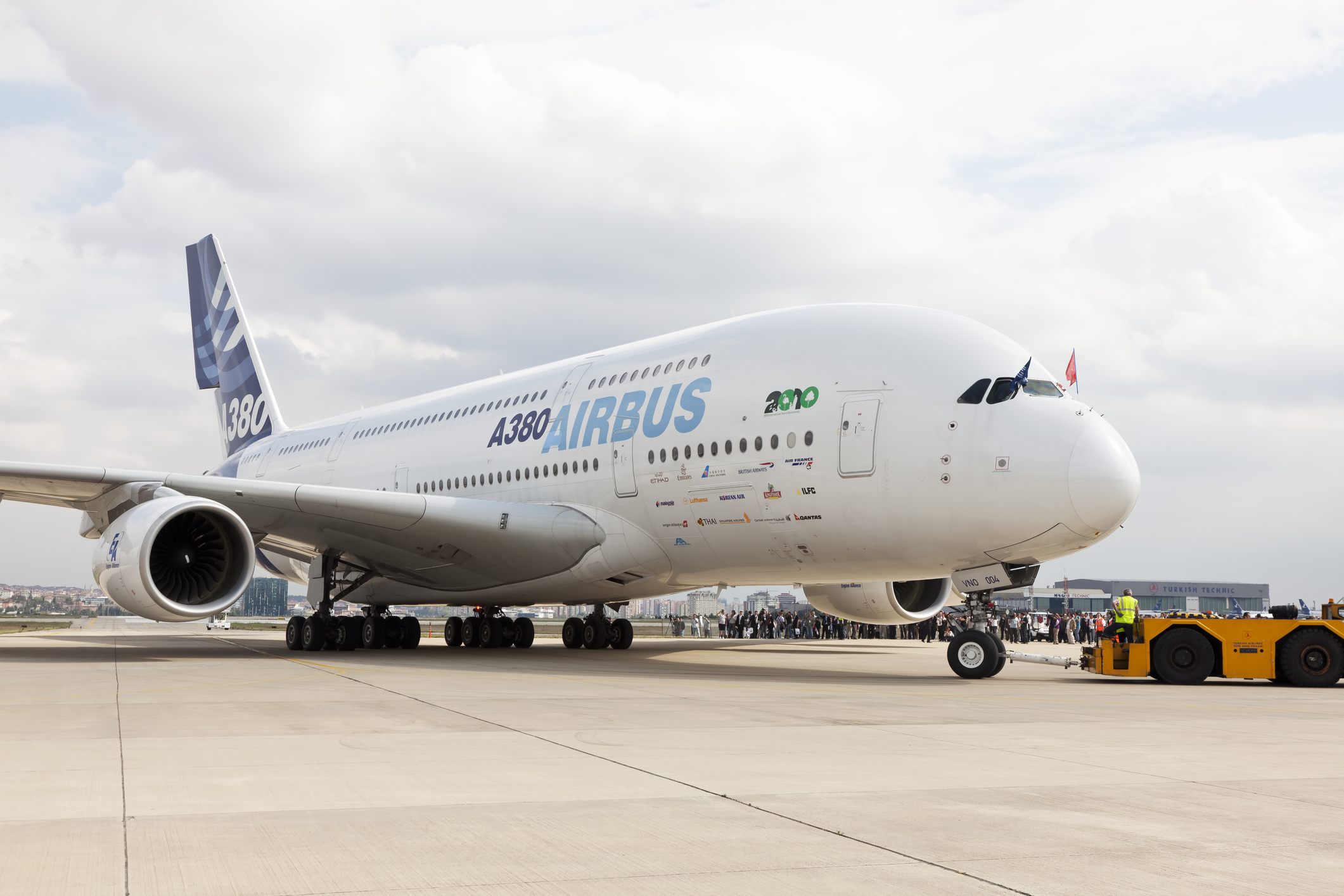 En Airbus A380 på landingsbanen med flyobservatører i baggrunden.