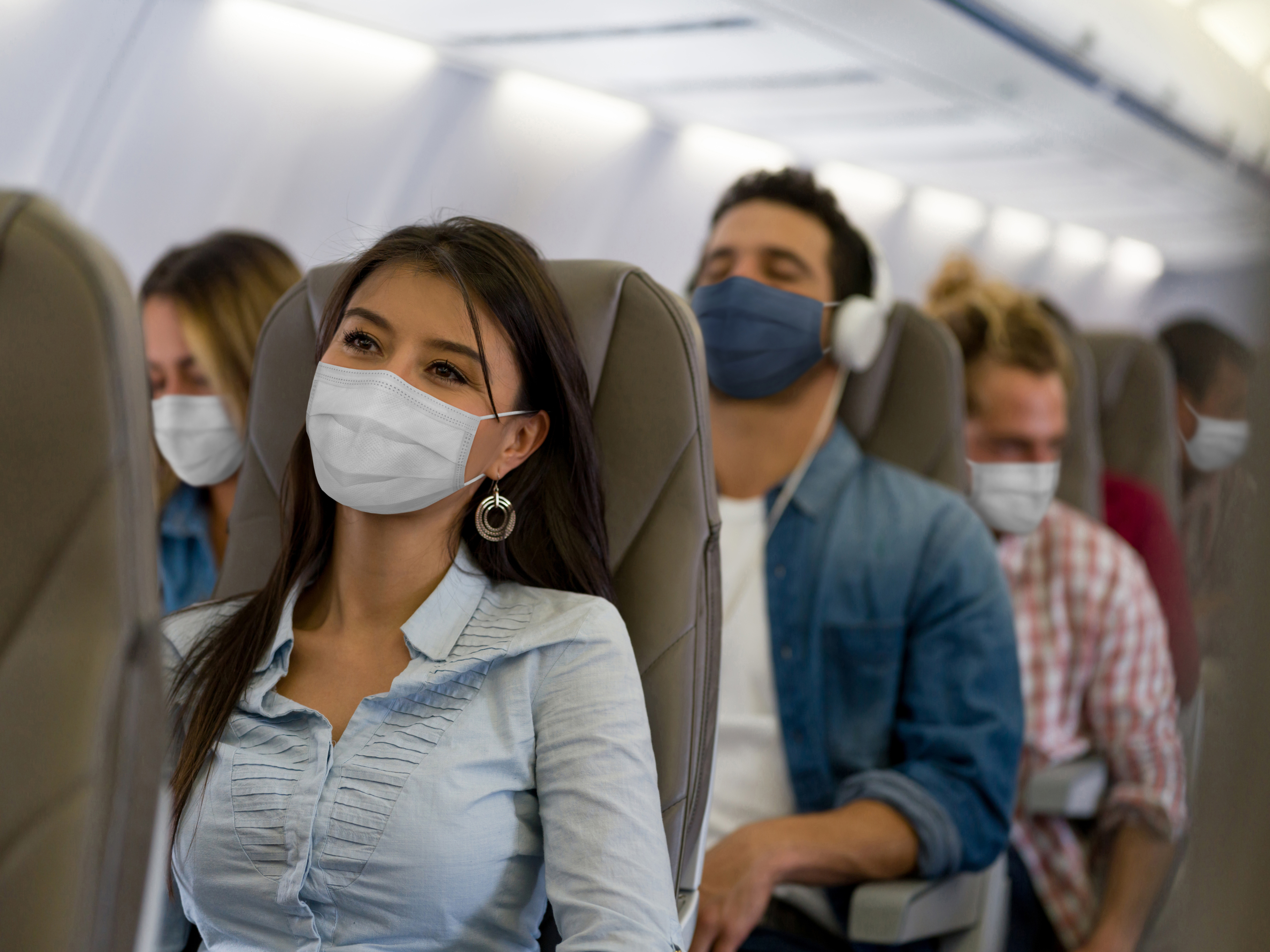 Passagerer med masker på flyet