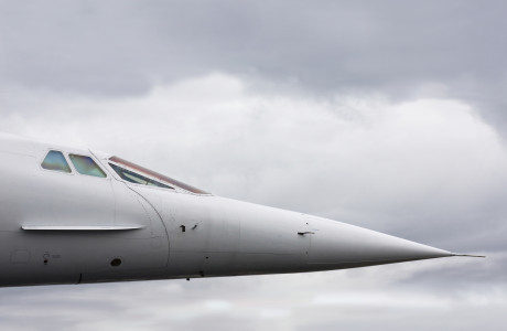 Næsen og cockpittet på en Concorde foran en overskyet himmel.