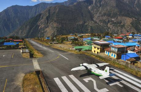 Startbanen i Lukla under godt vejr, et propel-fly er lige begyndt at lette.