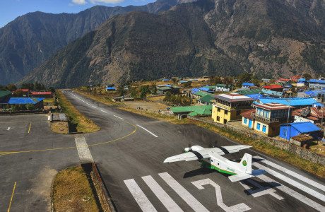 Startbanen i Lukla under godt vejr, et propel-fly er lige begyndt at lette.