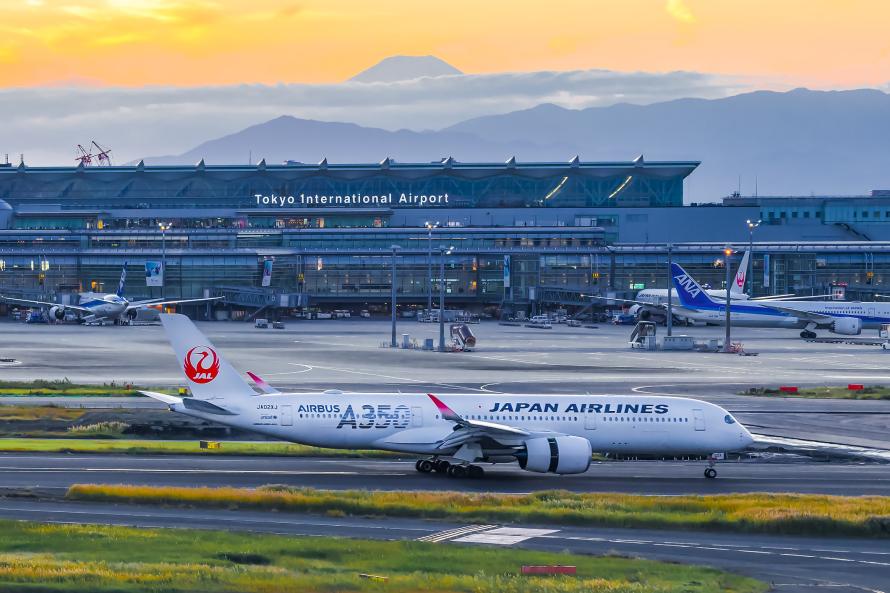 En terminal i Tokyo Haneda med bjerge i baggrunden.