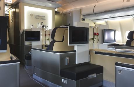 Lufthansa First Class med sæder og skærme.